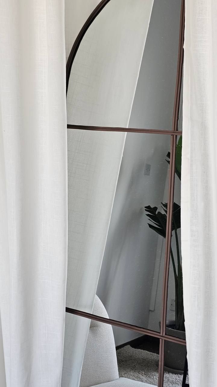 Arched mirror and linen curtains